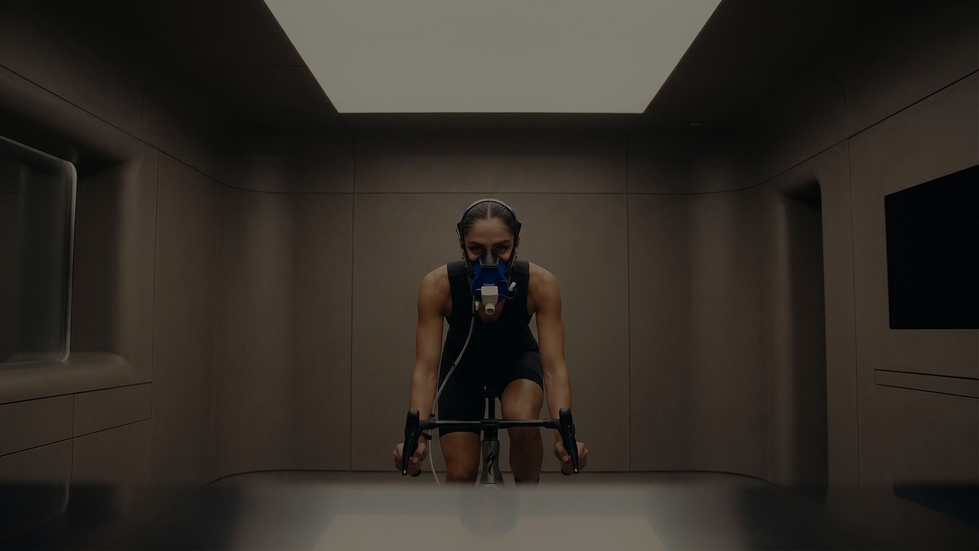 Athlete cycling with performance masks in laboratory.