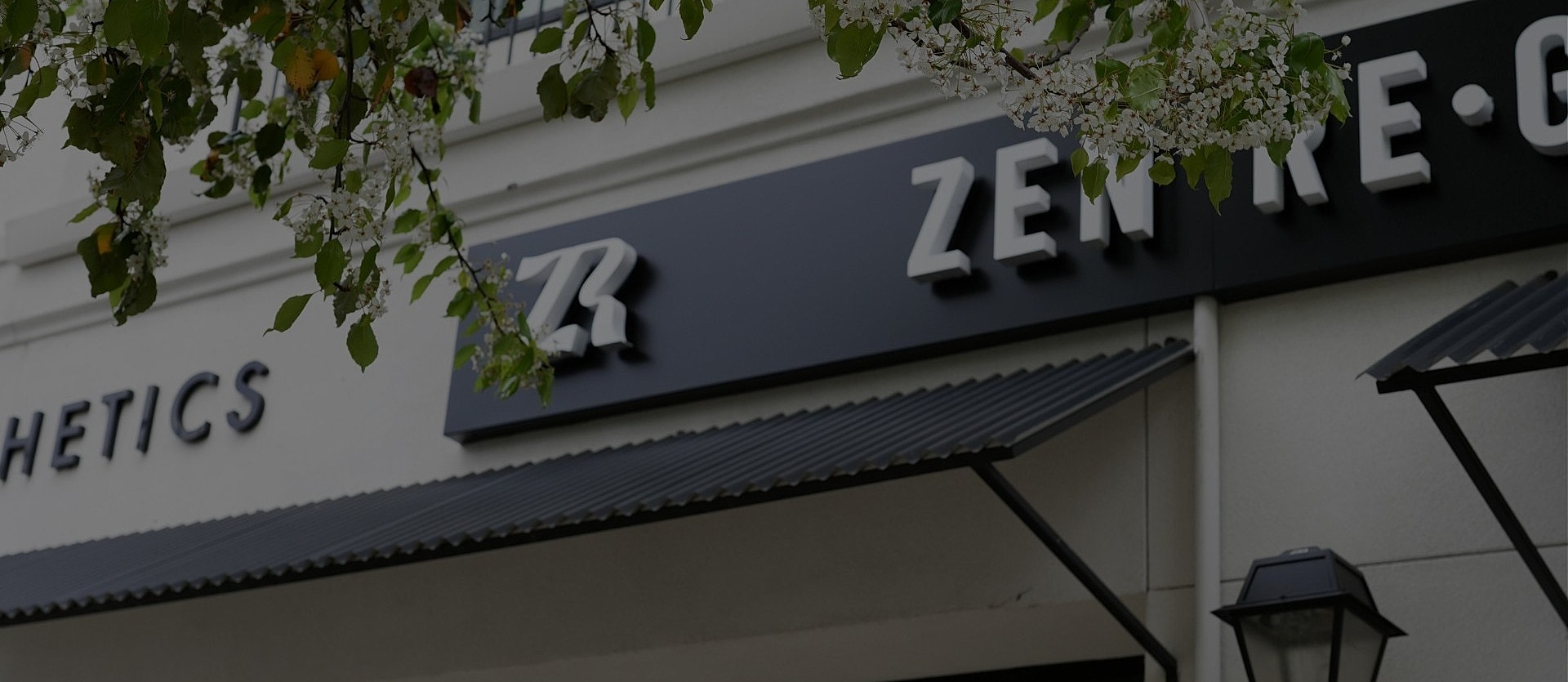 Zen aesthetics storefront with green leaves overhead.