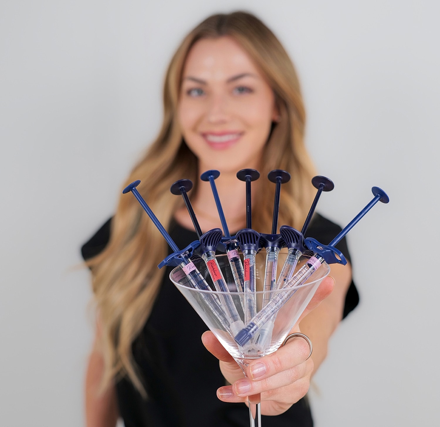 Syringes displayed creatively in a martini glass.