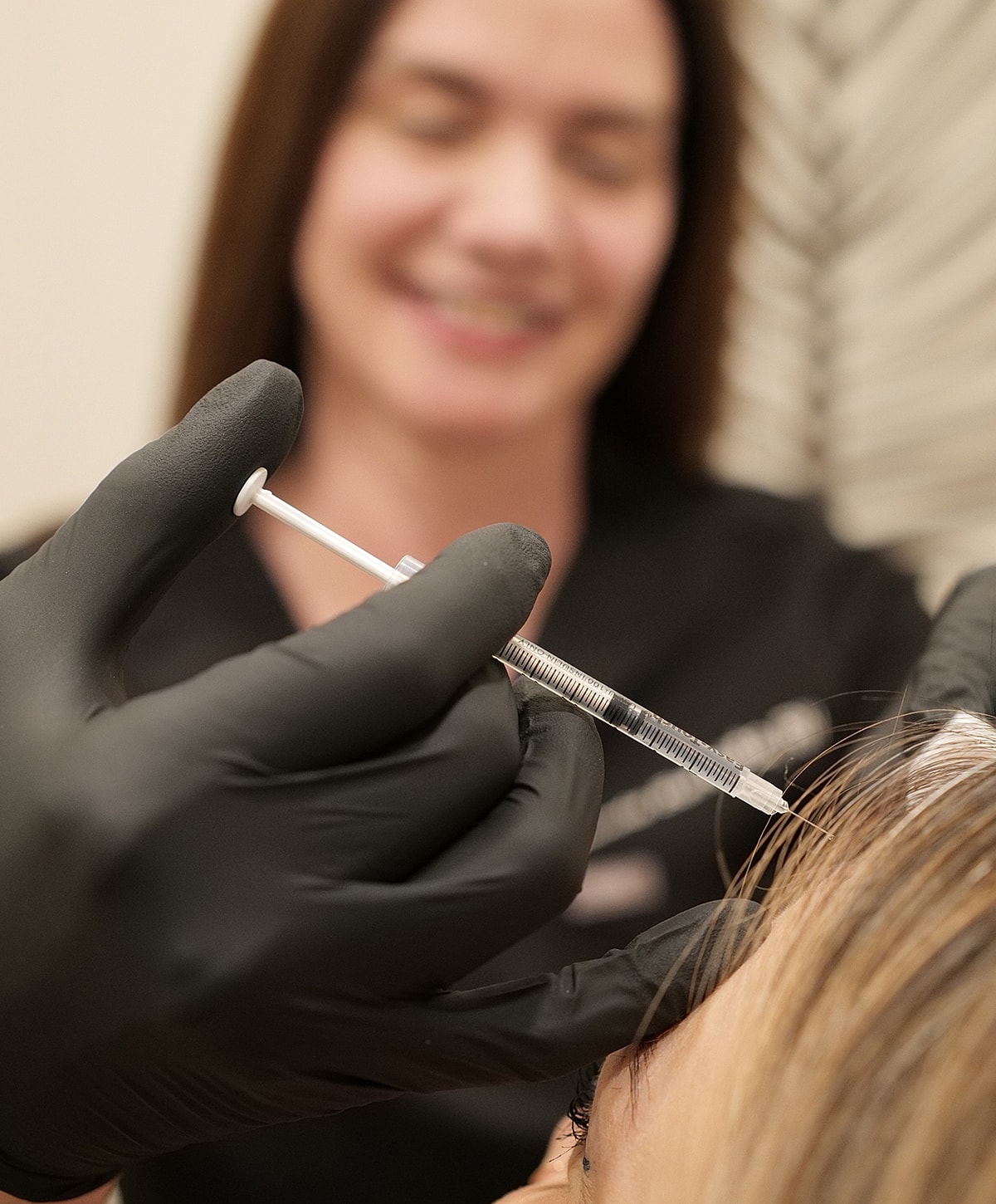 Aesthetic procedure with syringe and gloved hands