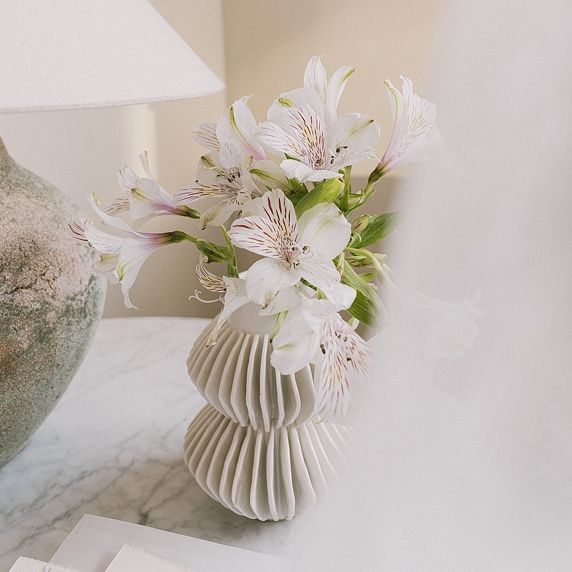 White flowers in a decorative vase on table.