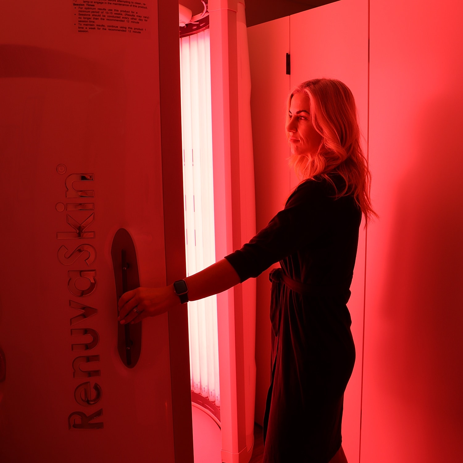 Woman entering red light therapy booth.