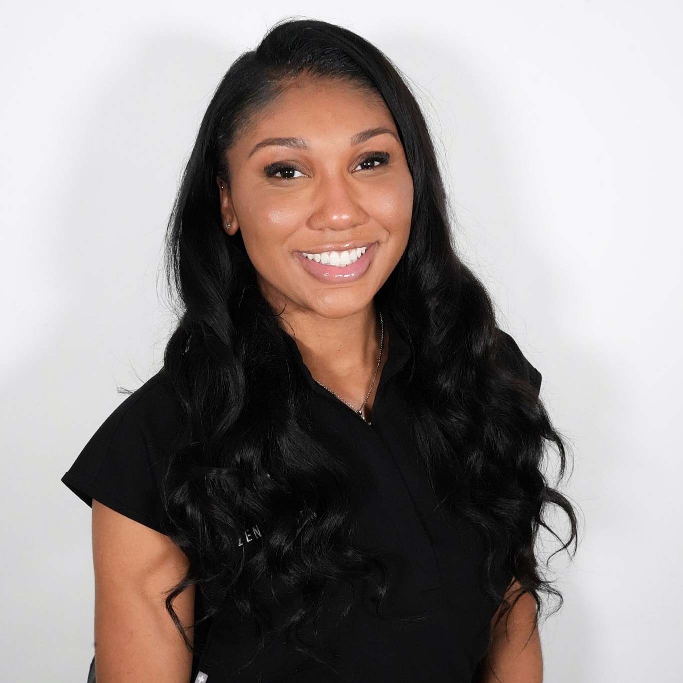 Smiling woman with long, wavy black hair.