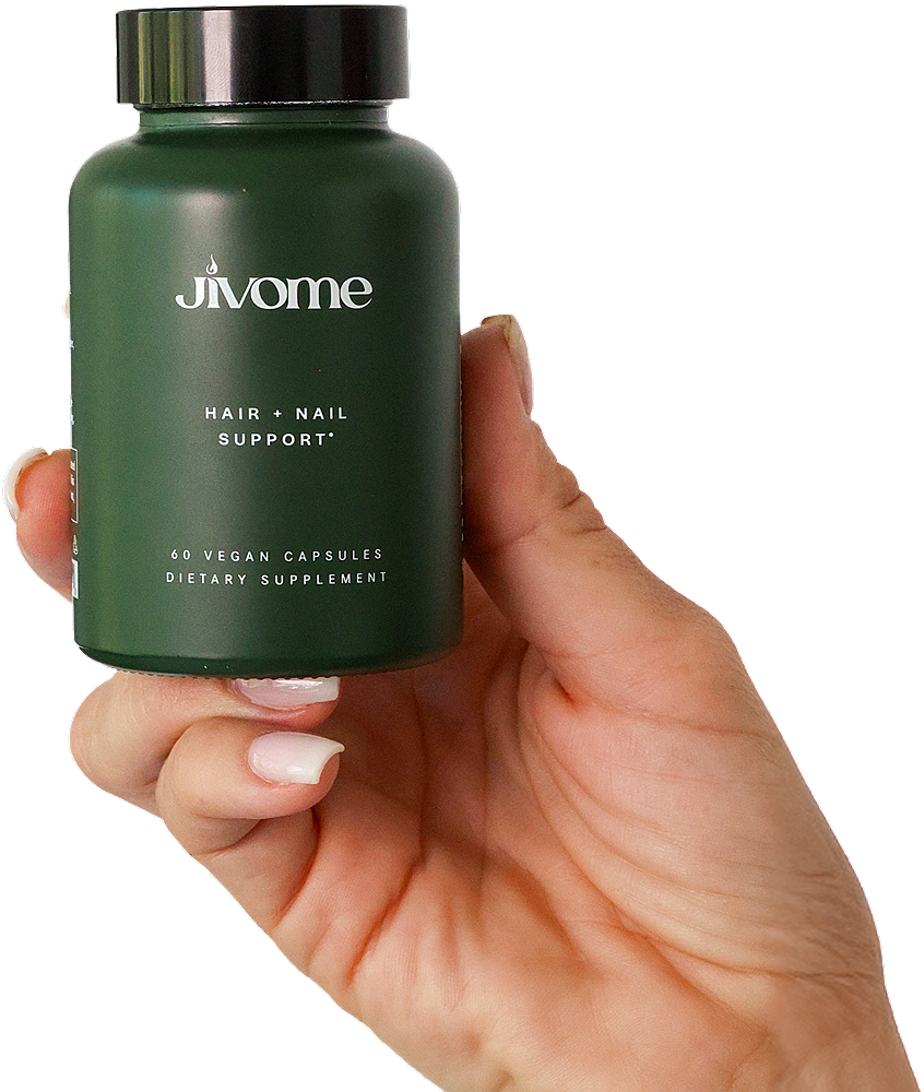 Bottle of hair and nail supplement in hand