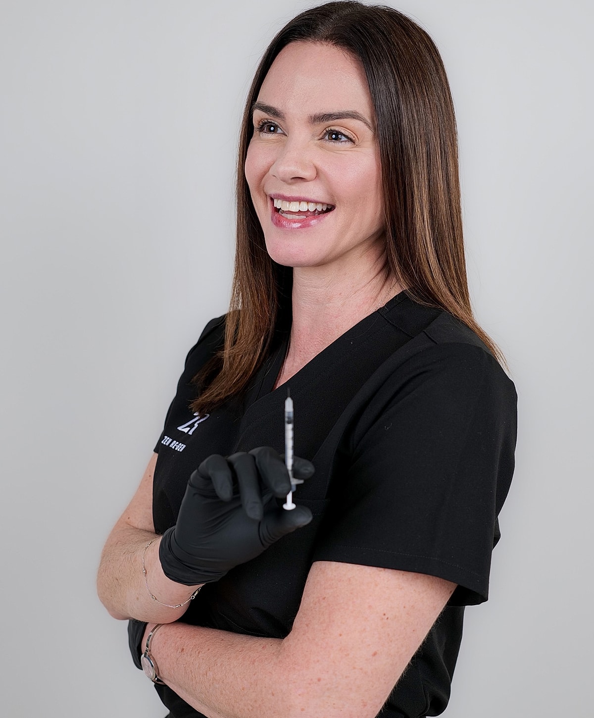 Smiling professional holding a syringe.