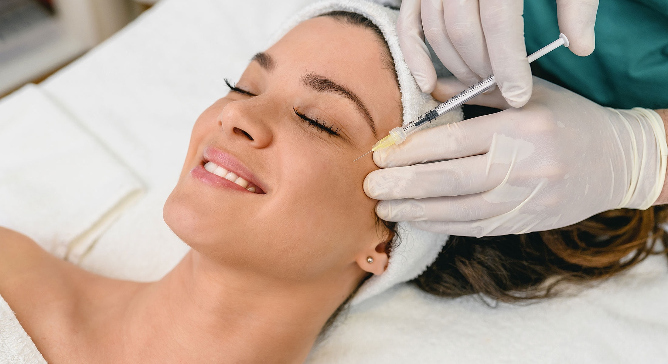 Woman receiving cosmetic injection treatment in clinic.