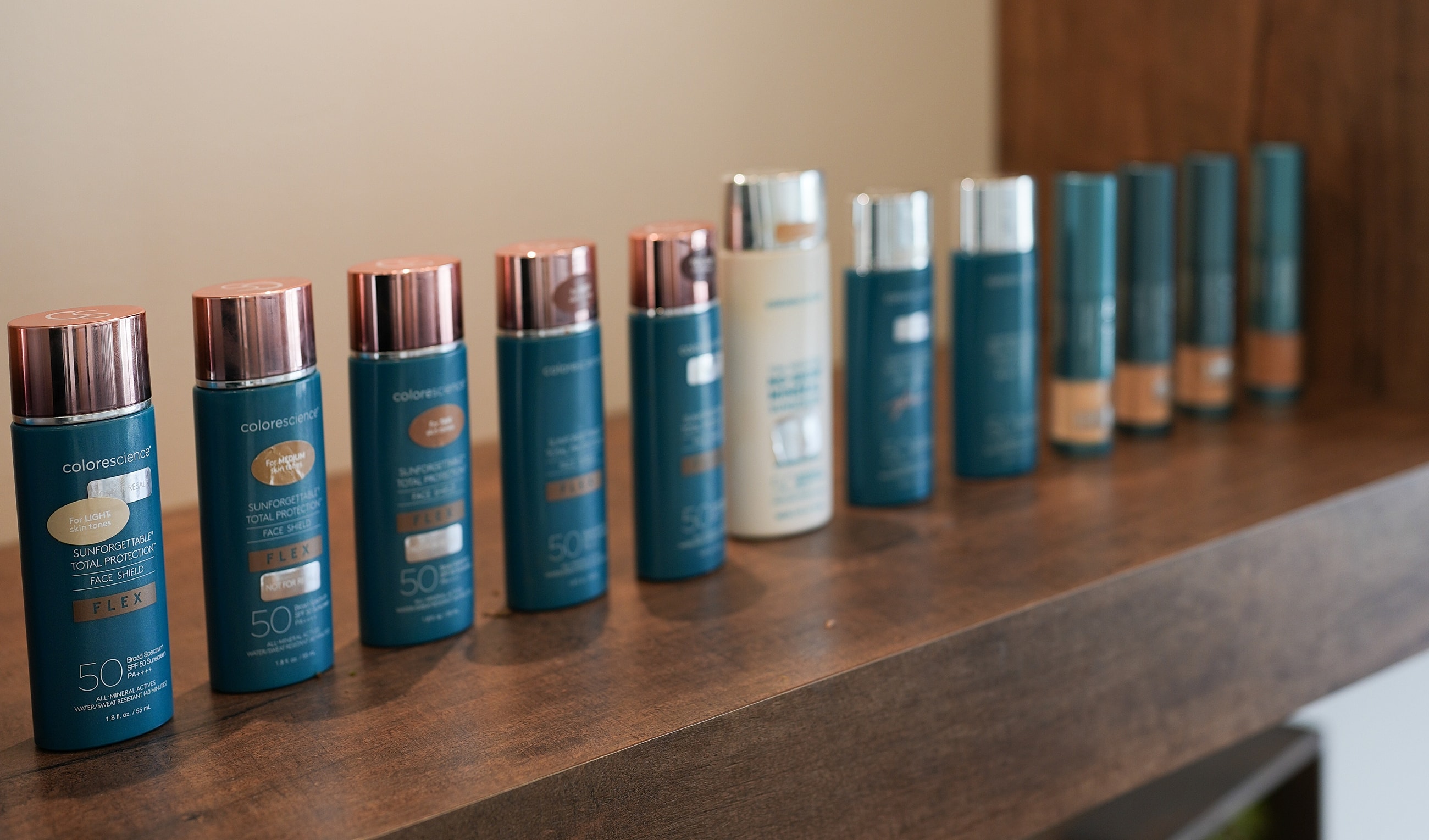 Skincare products arranged on a wooden shelf.