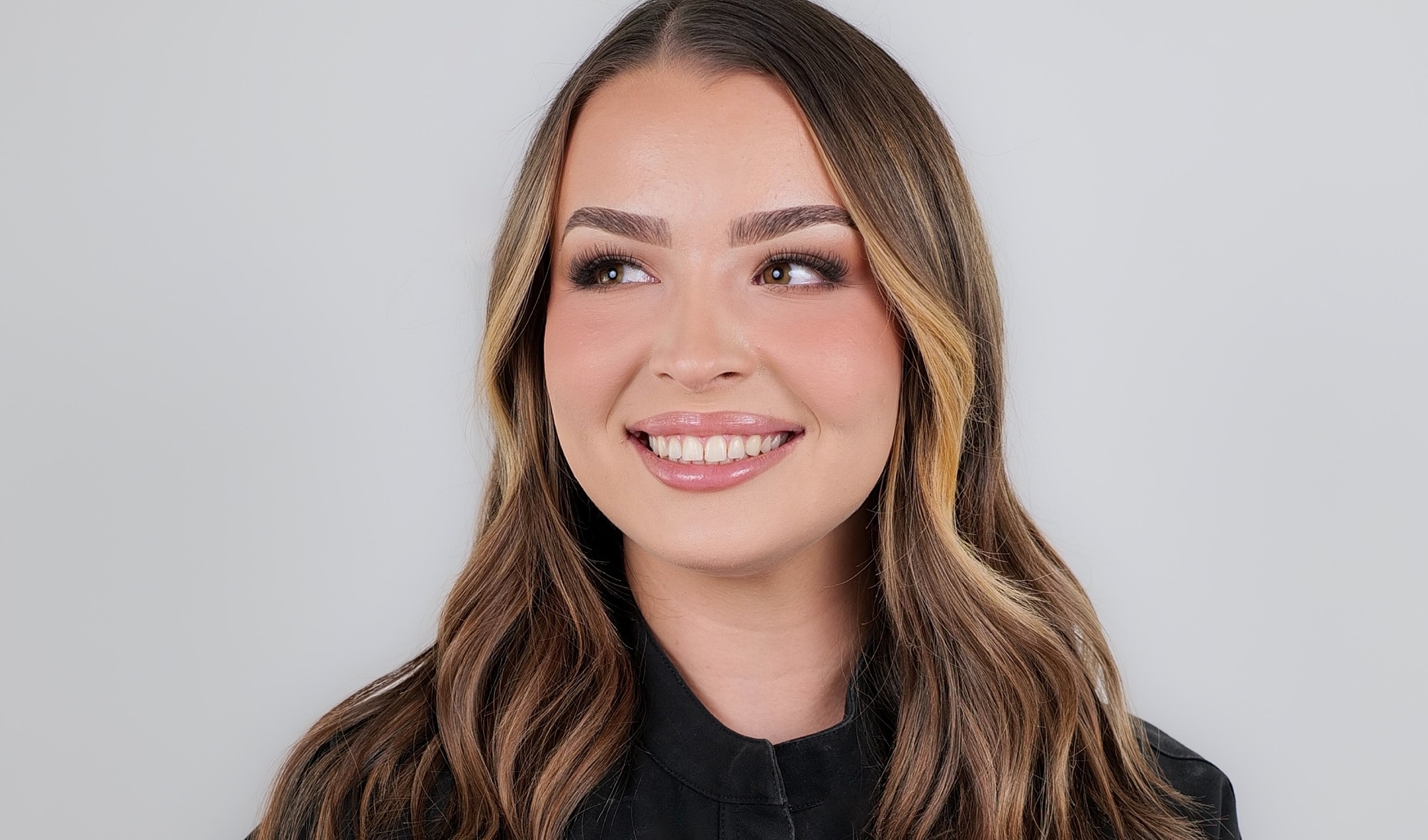 Smiling woman with long, wavy hair.