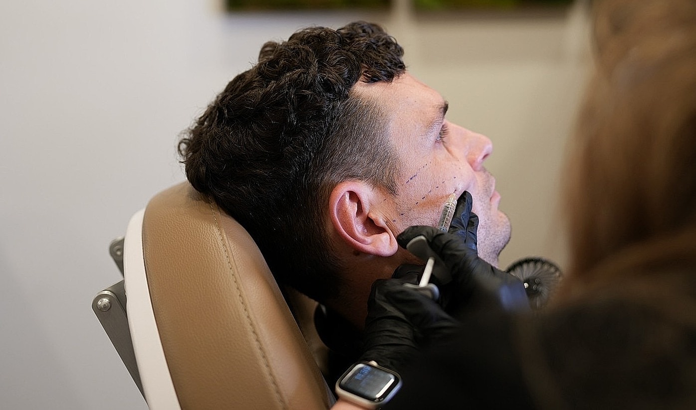 Man receiving cosmetic treatment in clinic setting.