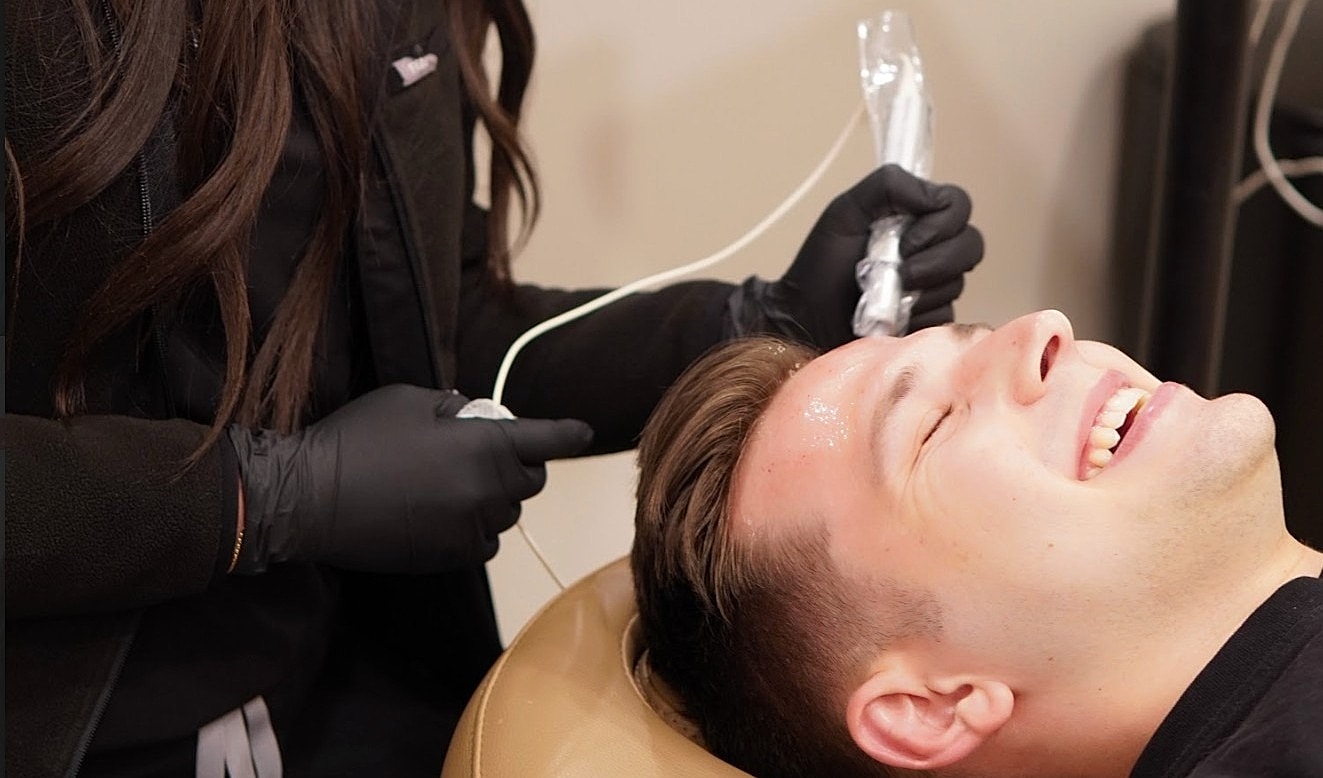 Man receiving a facial treatment in salon chair.