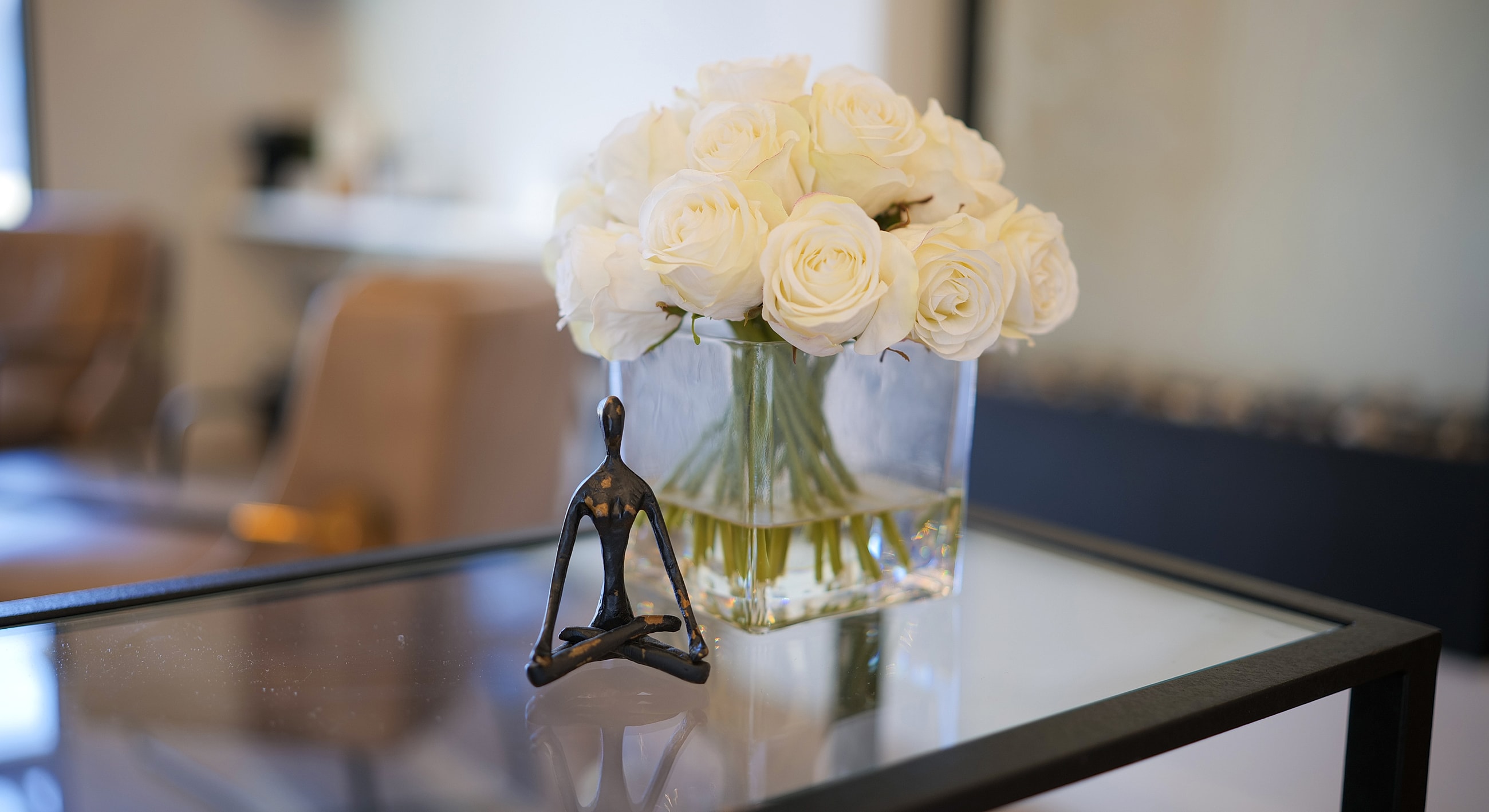 White roses and a decorative figure on table.